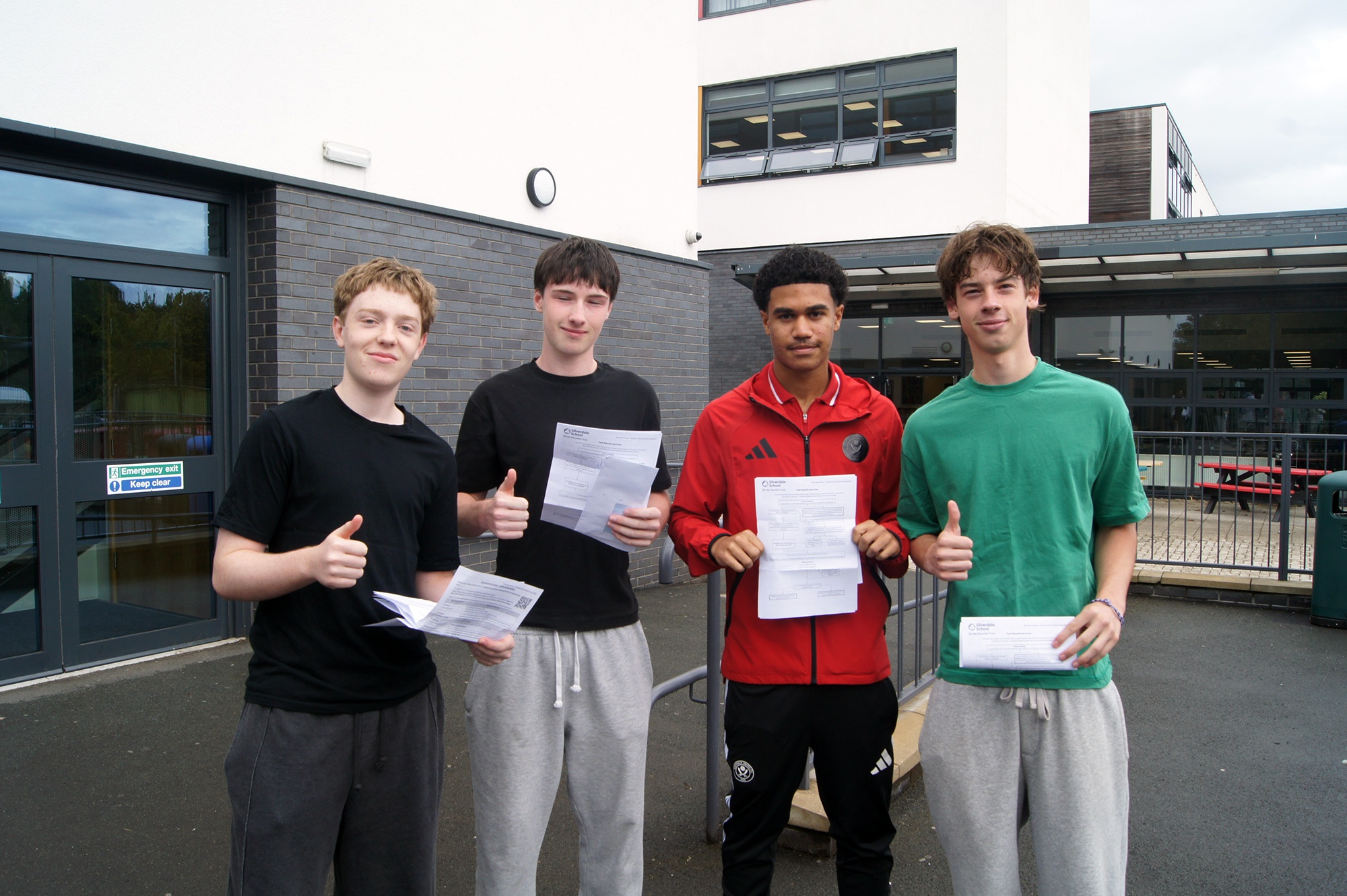 Four Silverdale students smiling and holding their results
