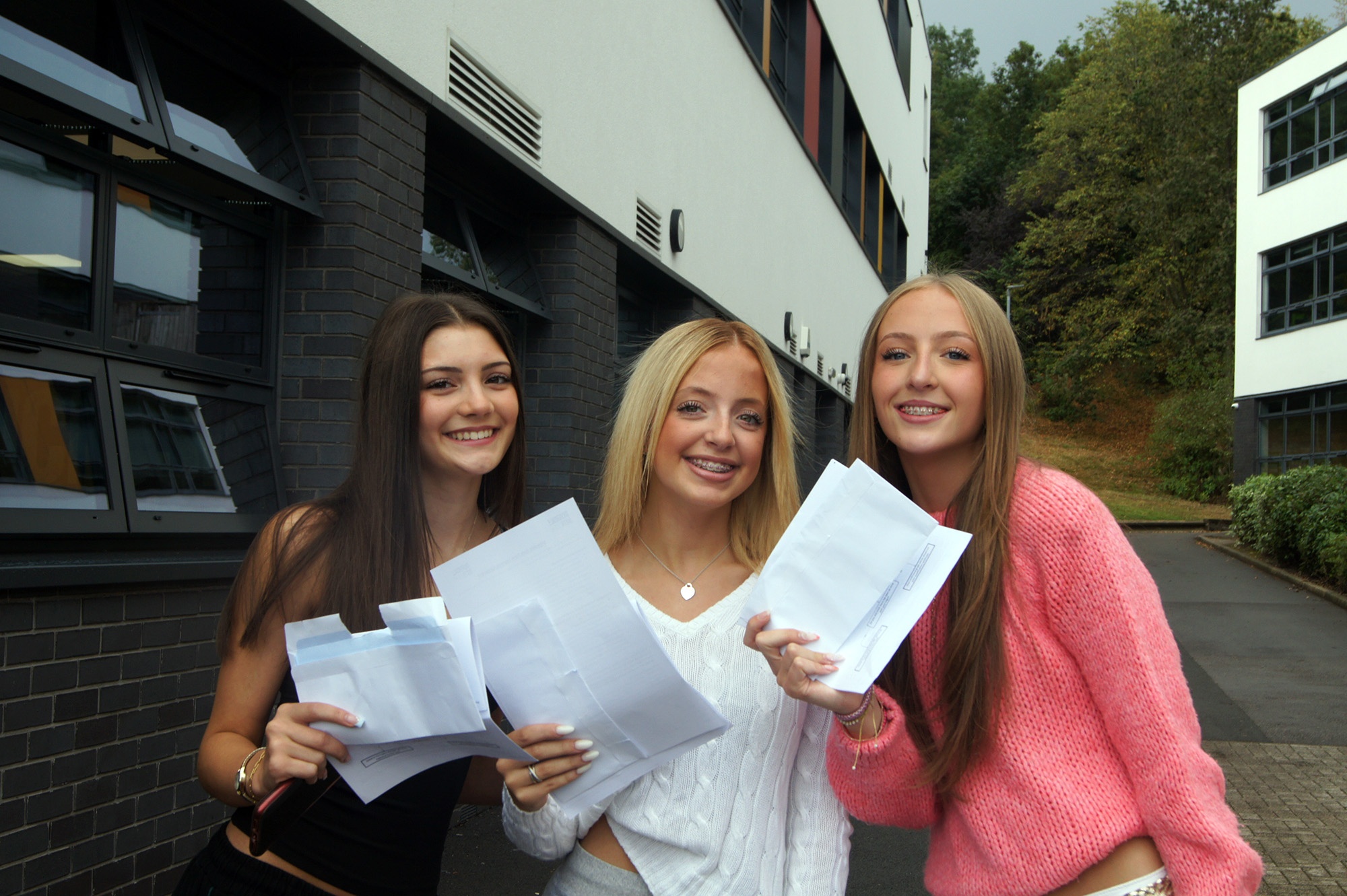 Three Silverdale students smiling and holding their results
